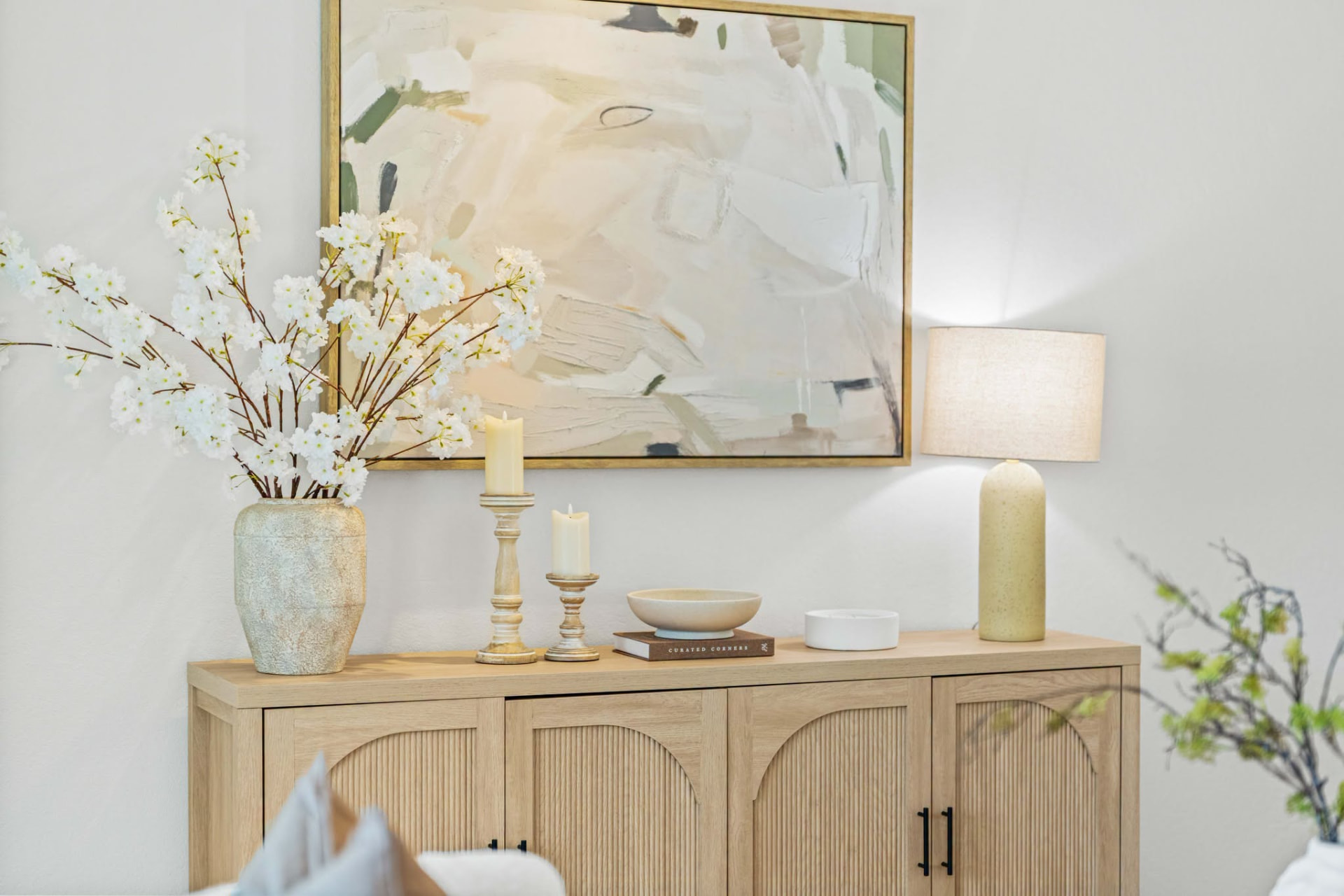 Entry console vignette with cherry blossoms, candles and abstract art styled by ONSTAGE