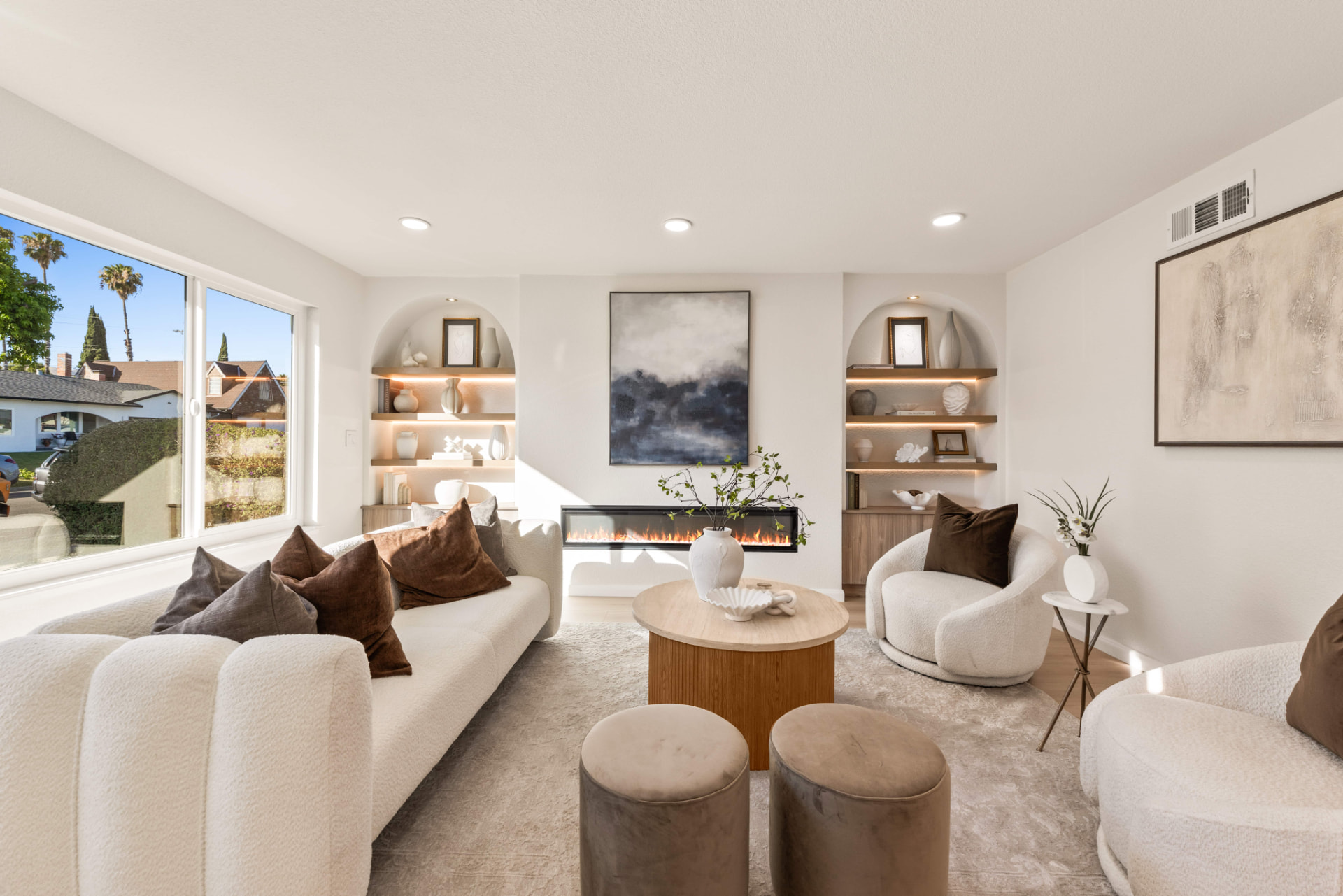Bright living room with fireplace and arched shelving styled by ONSTAGE