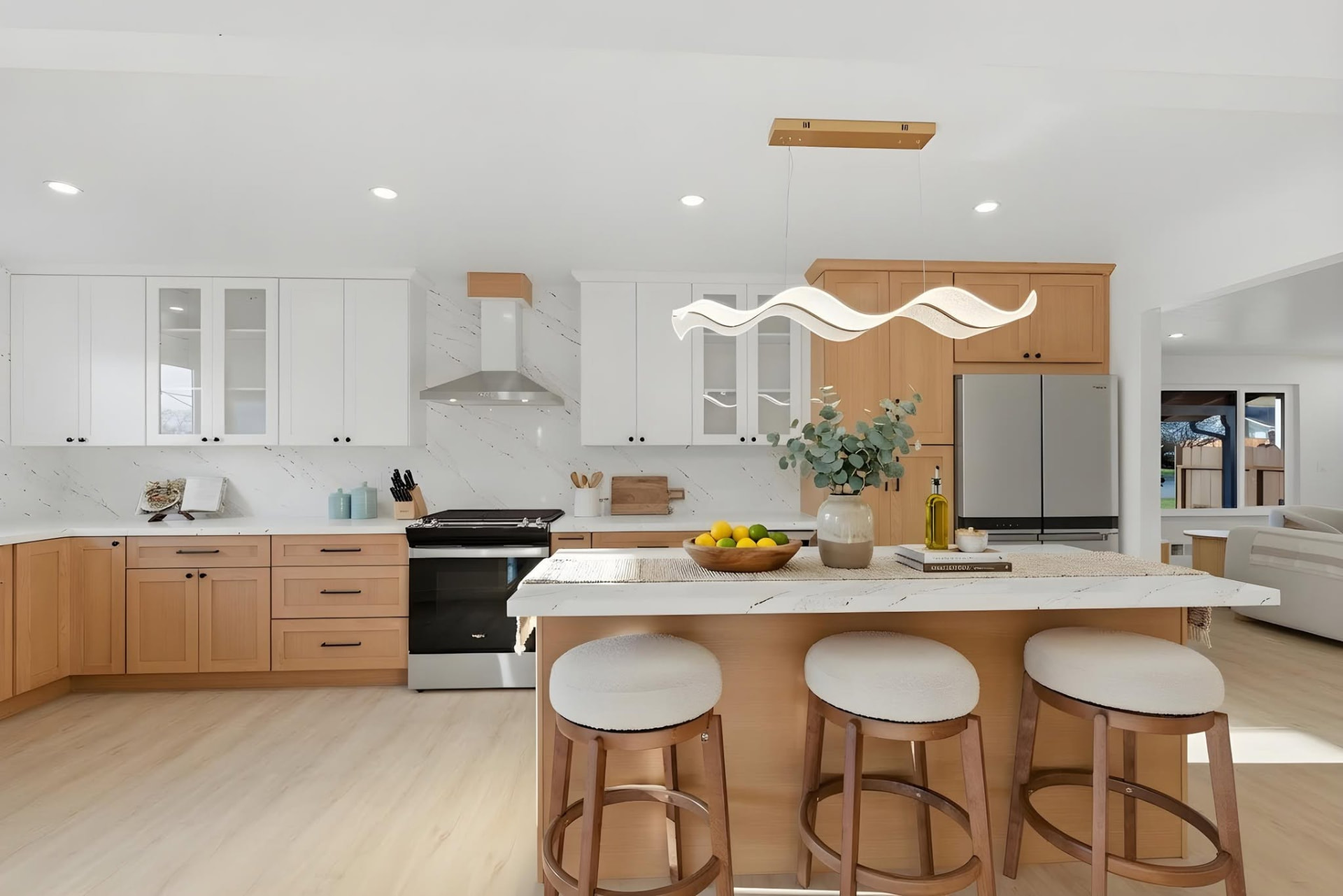 Open kitchen with marble island, wood cabinetry and boucle bar stools styled by ONSTAGE