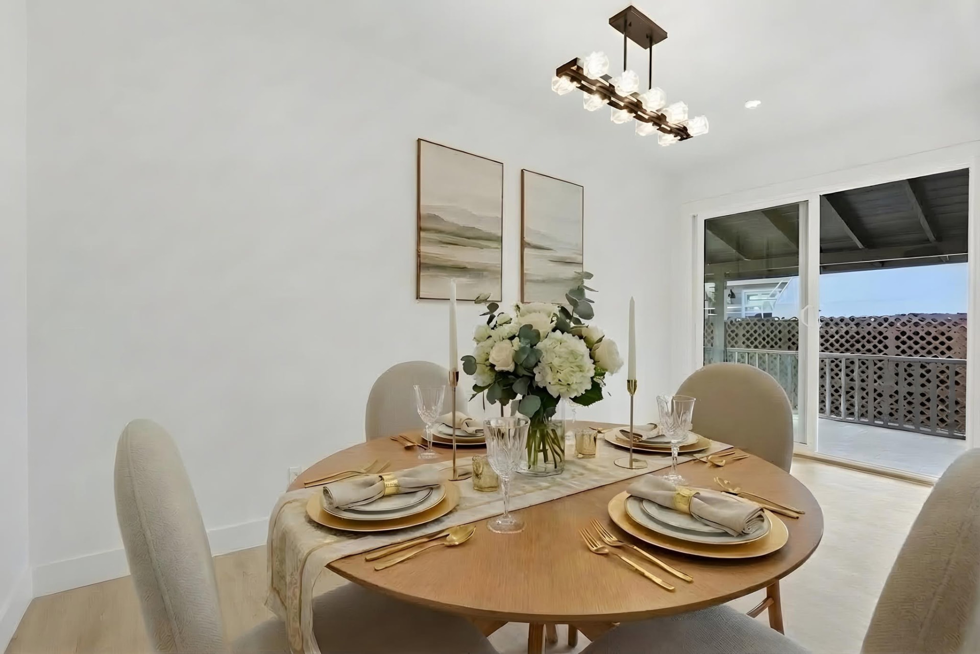Dining nook with round oak table, gold flatware and white hydrangeas styled by ONSTAGE